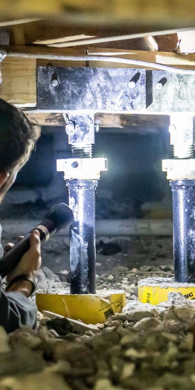 Quality Foundation Repair Austin technician installing crawl space floor support jacks.