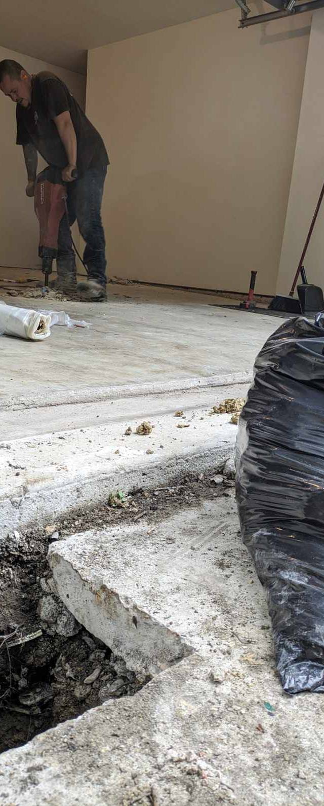 Quality Foundation Repair Austin worker operating a jackhammer to excavate a concrete floor for crawl space expansion.