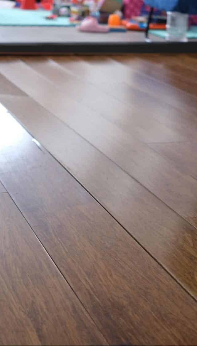 Quality Foundation Repair Austin inspecting uneven floors with visible floor sagging and gaps in wood floorboards.