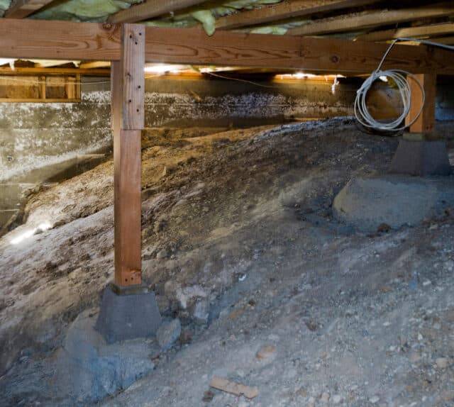 Quality Foundation Repair Austin inspecting sagging crawl space with exposed soil and moisture damage.