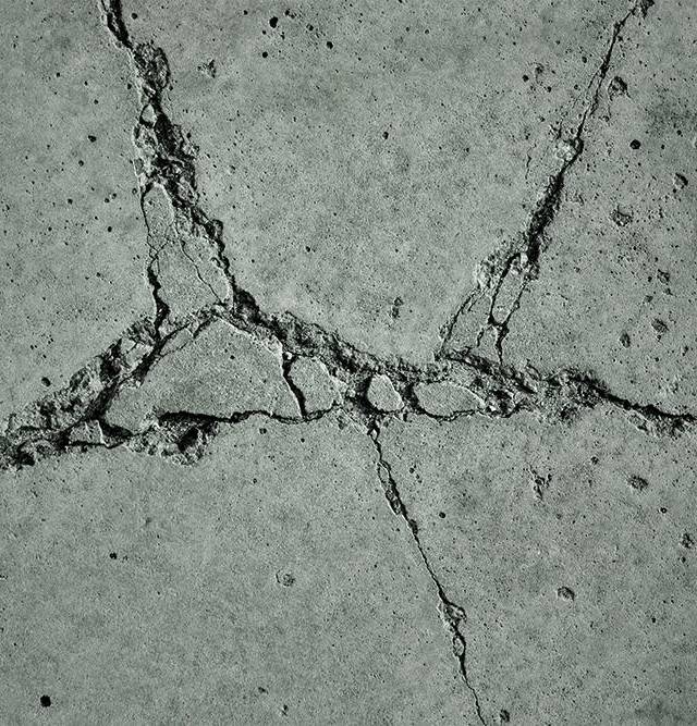 Quality Foundation Repair Austin inspecting severe cracks in a concrete foundation slab.